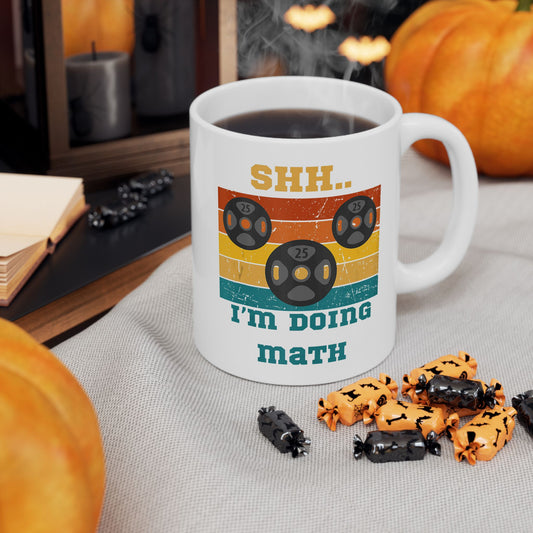 Person holding a mug with Shh I'm Doing Math gym nerd humor graphic.