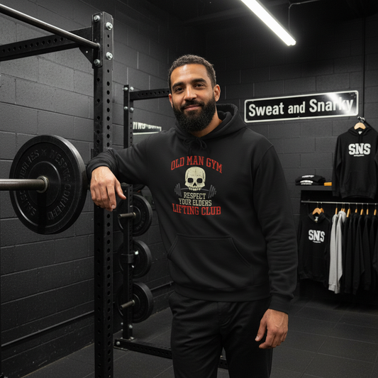 Man wearing a black hoodie with text in a gym setting