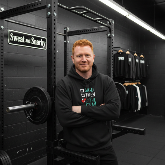 Man standing in a gym with 'Sweat and Snarky' branding visible