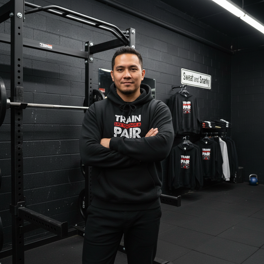 Man wearing a black hoodie with visible branding in a gym setting