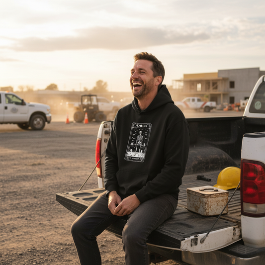 Man sitting on a pickup truck bed with a construction site in the background