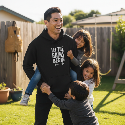Man wearing a hoodie with text, surrounded by two children in a backyard setting.