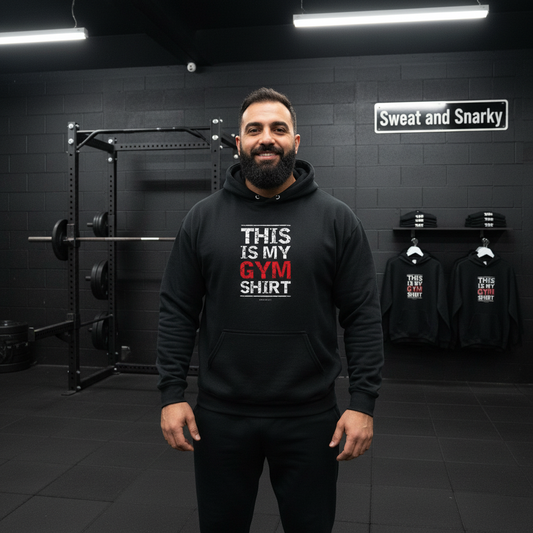 Man wearing a black hoodie with text in a gym setting