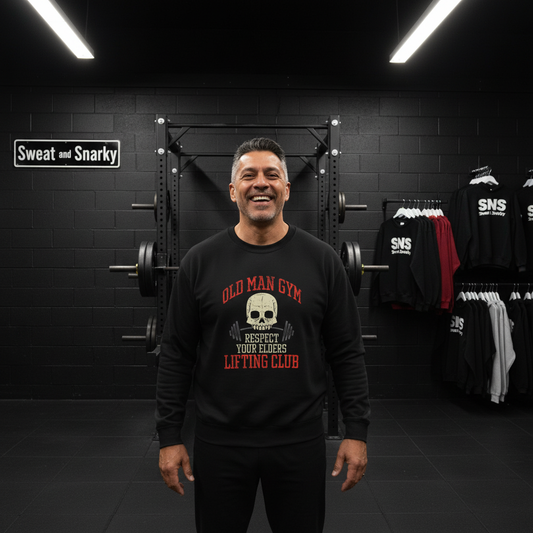 Man wearing a black sweatshirt with 'Old Man Gym' text in a gym setting
