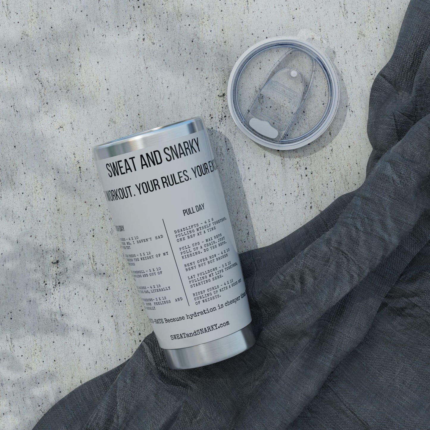 Tumbler with text on a concrete surface with a gray sleeve.