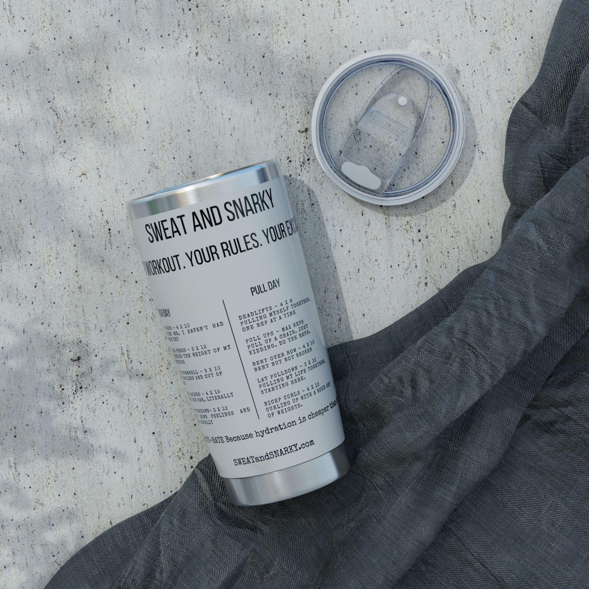 Tumbler with text on a concrete surface with a gray sleeve.